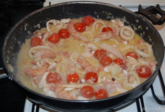 Grande padella per paella piastra con piatti di pesce e di riso